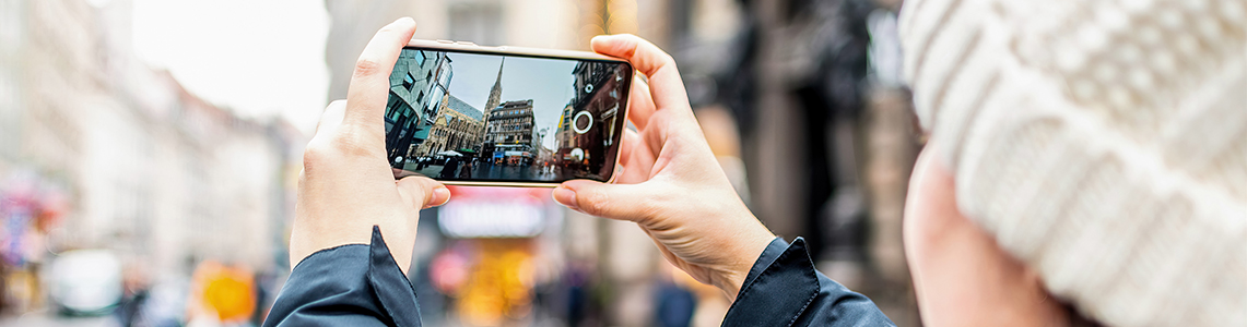 A person taking a photo of a street on a phone A person taking a photo of a street on a phone