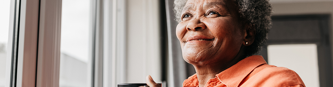 A smiling older woman holding a mug A smiling older woman holding a mug